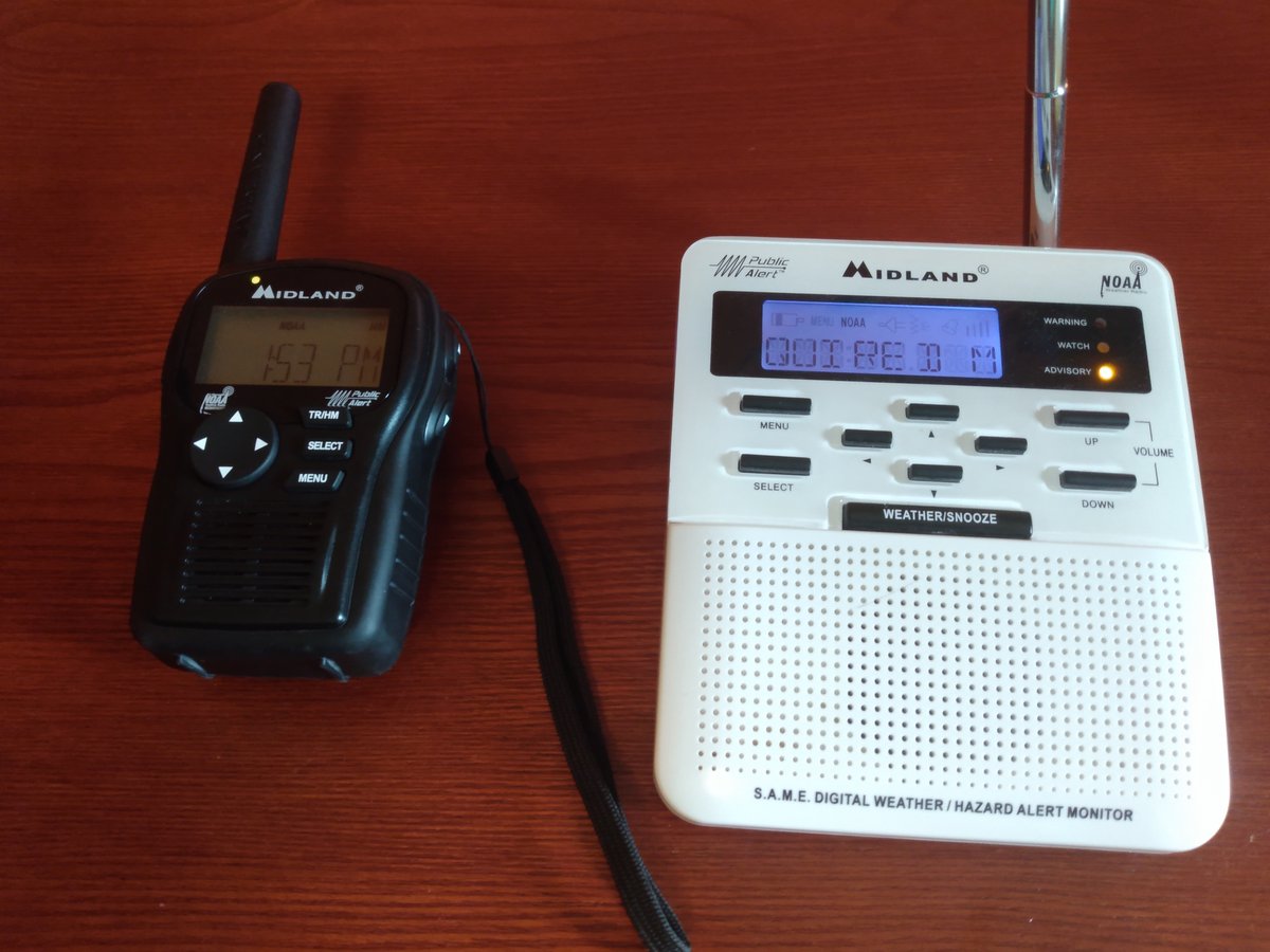 A weather radio and a pair of walkie-talkies on a kitchen counter